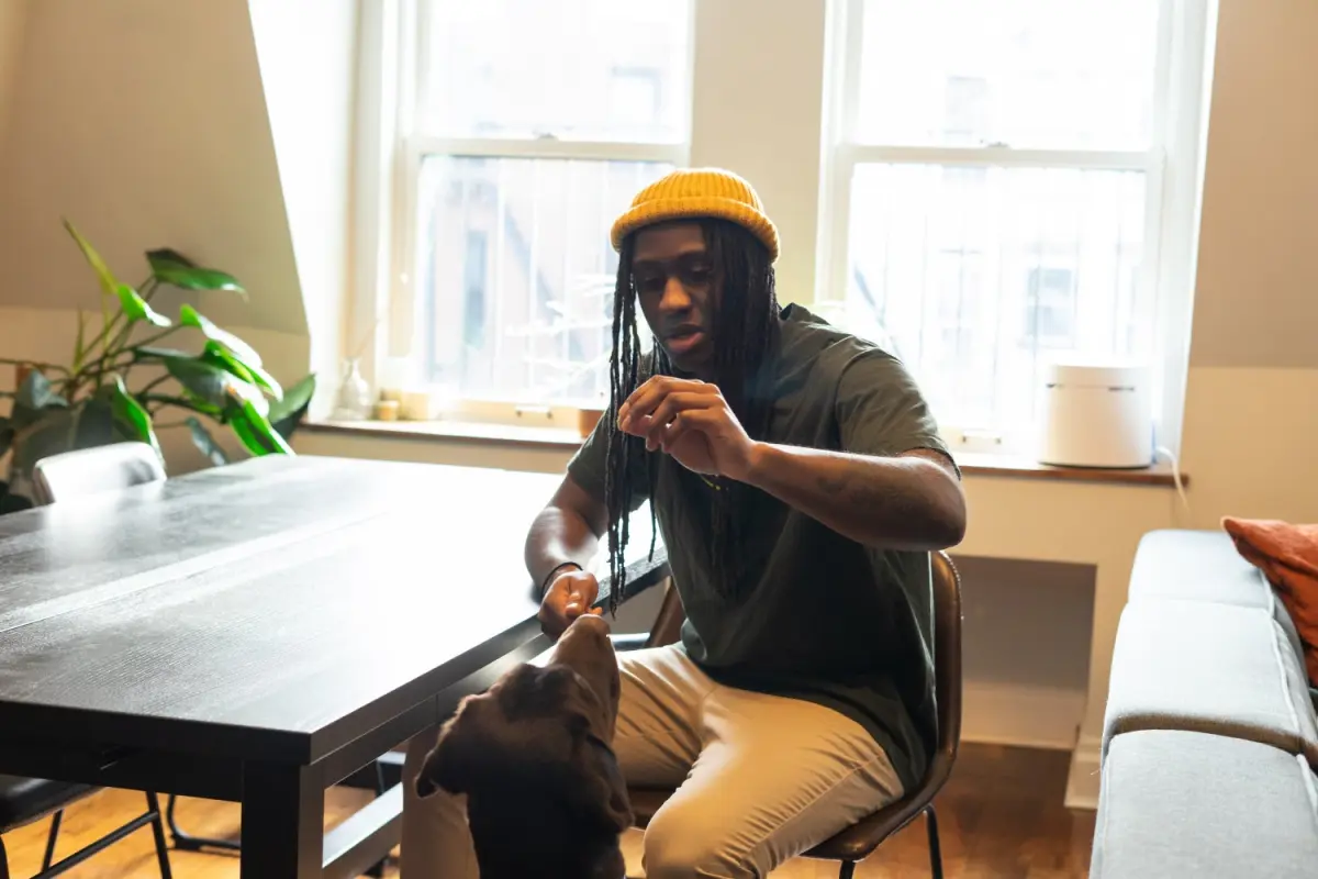 A man sitting at a table in a bright workspace, in conversation